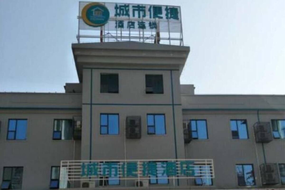 Un bâtiment avec une enseigne indiquant « City Comfort Inn » et une autre indiquant « City Comfort Hotel ».