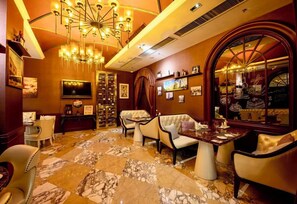 A luxurious hotel lobby with a marble floor, elegant seating, a large chandelier, and a wine display. - Crowne Plaza Zhengzhou by IHG (Zhengzhou)