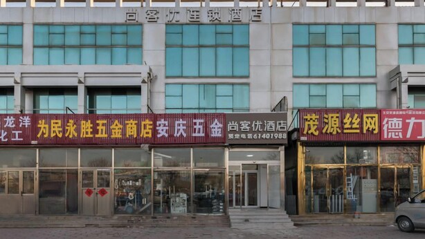 A building with multiple storefronts, including a hotel and various shops. - Shankee Hotel (Shunyi)