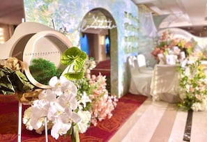 Um corredor de casamento com decorações florais e uma placa com a inscrição 'LIUSHAOKE&XUFEI'.