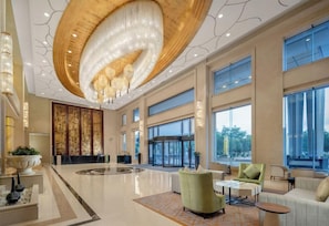A spacious lobby with a large chandelier, seating area, and large windows. - Holiday Inn Foshan Nanhai Central by IHG (Foshan)