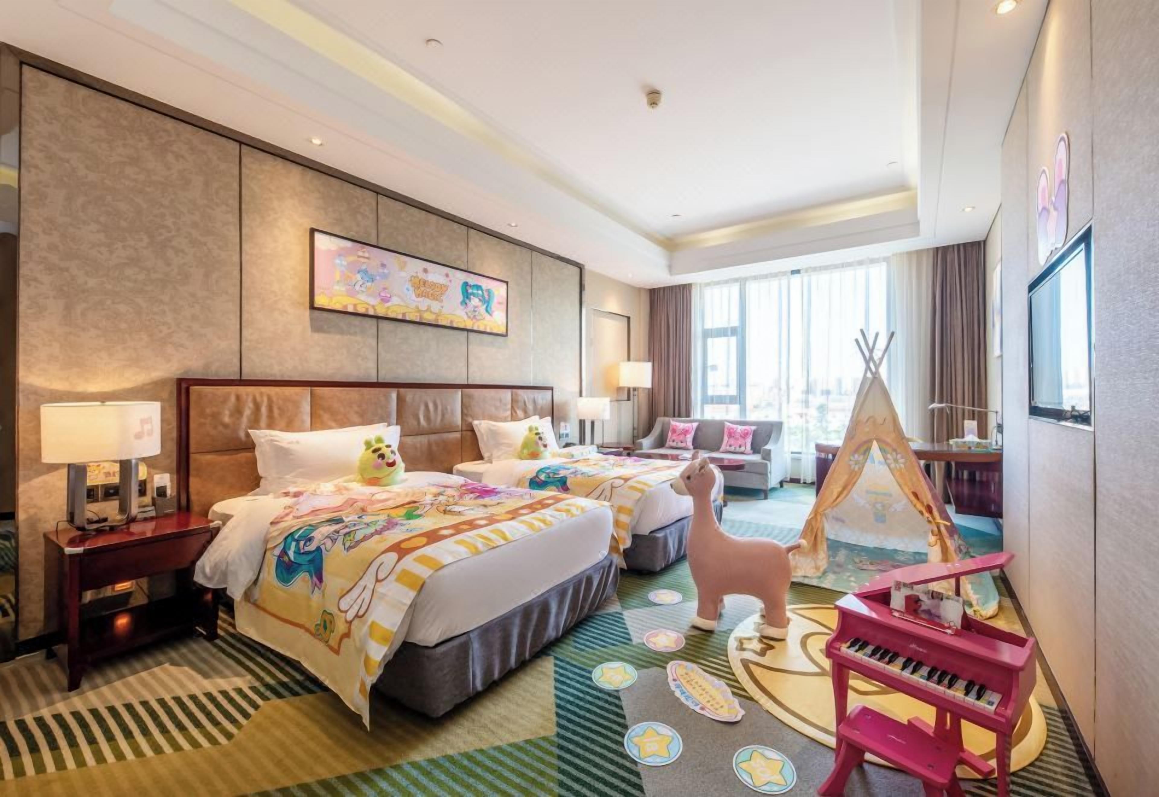 Ein Hotelzimmer mit einem großen Bett, einem Schreibtisch, einem Sessel, einem Klavier, einem Zelt und einer Wand mit einem Gemälde.