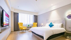 A hotel room with a large bed, two yellow chairs, a TV on the wall, and a window with curtains. - Magnotel Yingda Road, Baoji (Baoji)