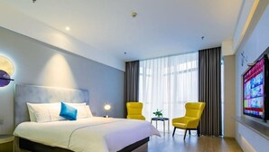 A hotel room with a bed, two chairs, a television, and a window with curtains. - Magnotel Yingda Road, Baoji (Baoji)