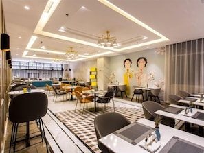 A modern dining area with tables, chairs, and a mural on the wall. - Magnotel Yingda Road, Baoji (Baoji)