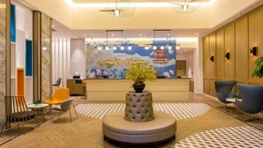 A hotel lobby with a reception desk, seating area, and a decorative centerpiece. - Magnotel Yingda Road, Baoji (Baoji)