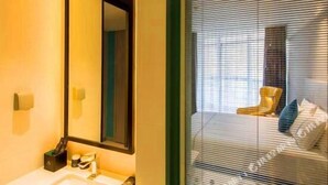 A hotel room with a large mirror, a sink, and a window with blinds. - Magnotel Yingda Road, Baoji (Baoji)