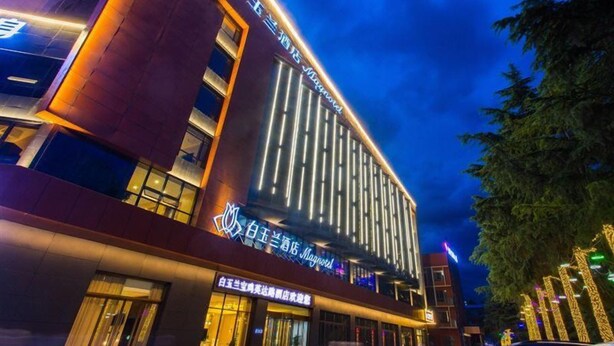 A modern hotel building with illuminated signage and vertical light strips. - Magnotel Yingda Road, Baoji (Baoji)