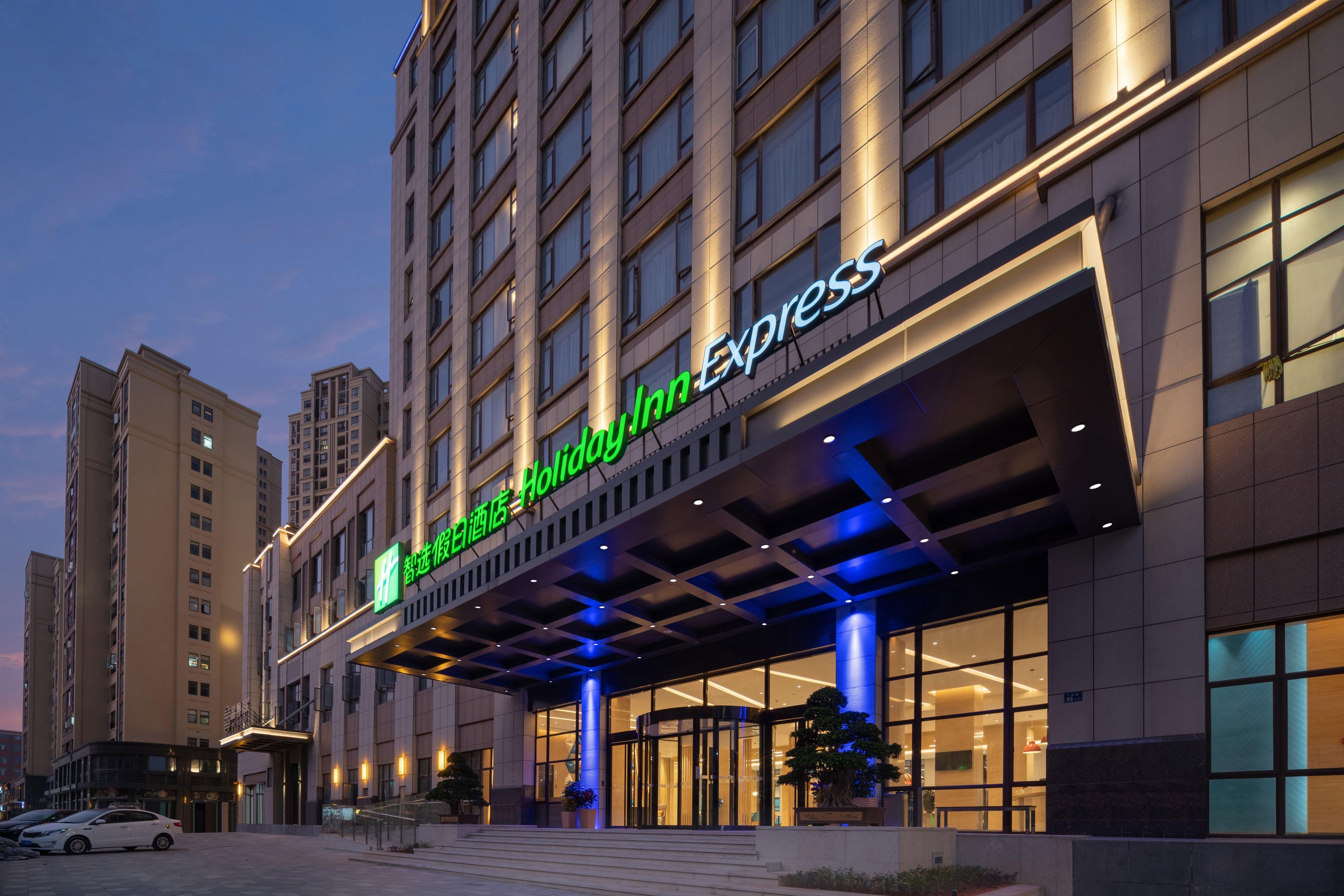 Ein Hotel mit einer modernen Fassade, großen Fenstern und einem markanten Eingang.