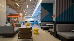 A modern indoor space with seating areas, tables, and a central column with a unique design. - Holiday Inn Express Jinjiang Anhai (Quanzhou)
