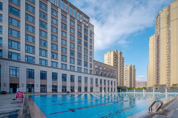 Una piscina con separadores de carriles, rodeada de edificios altos.