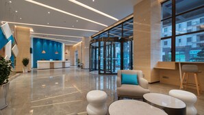 A modern lobby with a reception desk, seating area, and large windows. - Holiday Inn Express Jinjiang Anhai (Quanzhou)