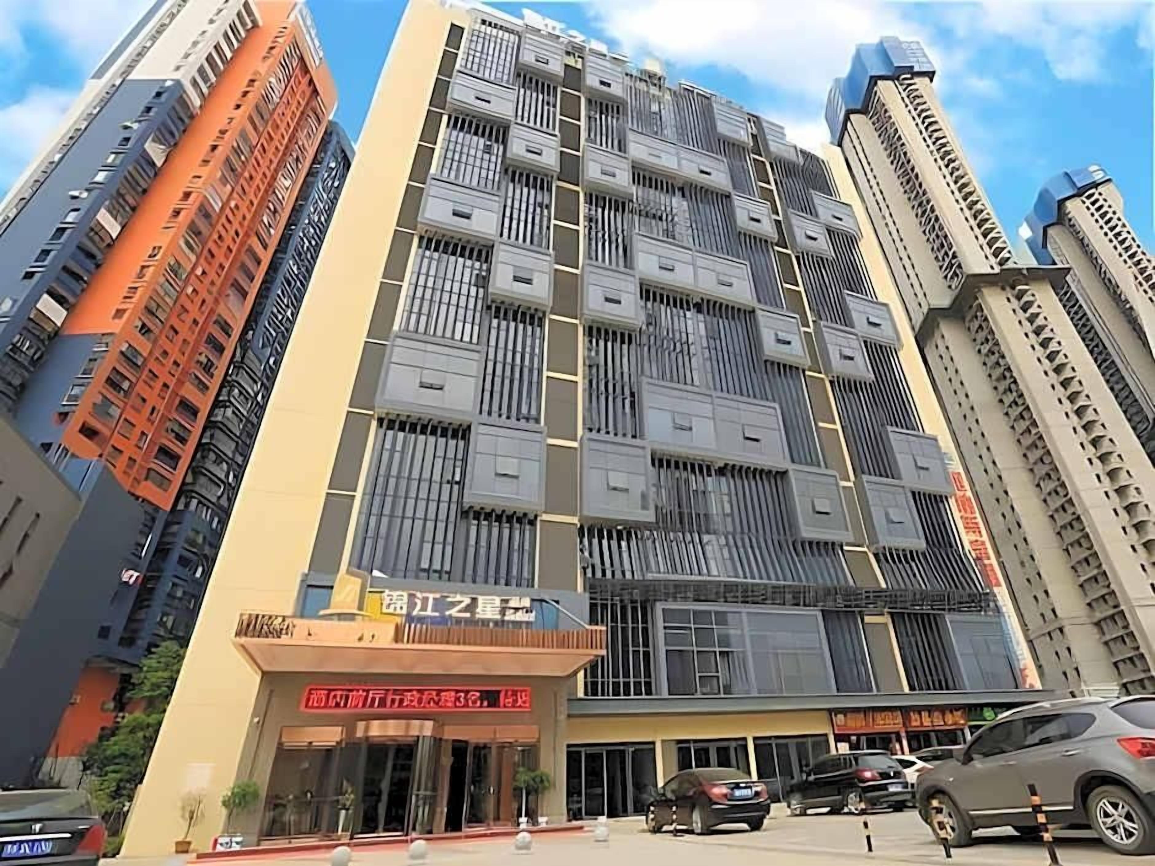 A multi-story building with a modern architectural design, featuring a prominent entrance with signage.