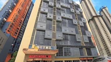 A multi-story building with a modern architectural design, featuring a prominent entrance with signage.
