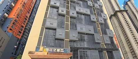 A multi-story building with a modern architectural design, featuring a prominent entrance with signage.