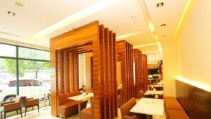 A modern restaurant interior with wooden partitions, seating arrangements, and a view of the outside. - Jinjiang Inn Select Hotel (Wuhan)