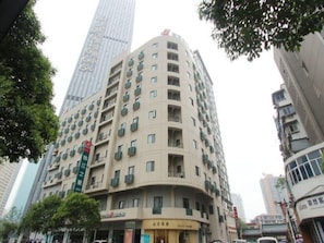 A multi-story hotel with balconies, a visible restaurant, and a large building in the background. - Jinjiang Inn Select Hotel (Wuhan)