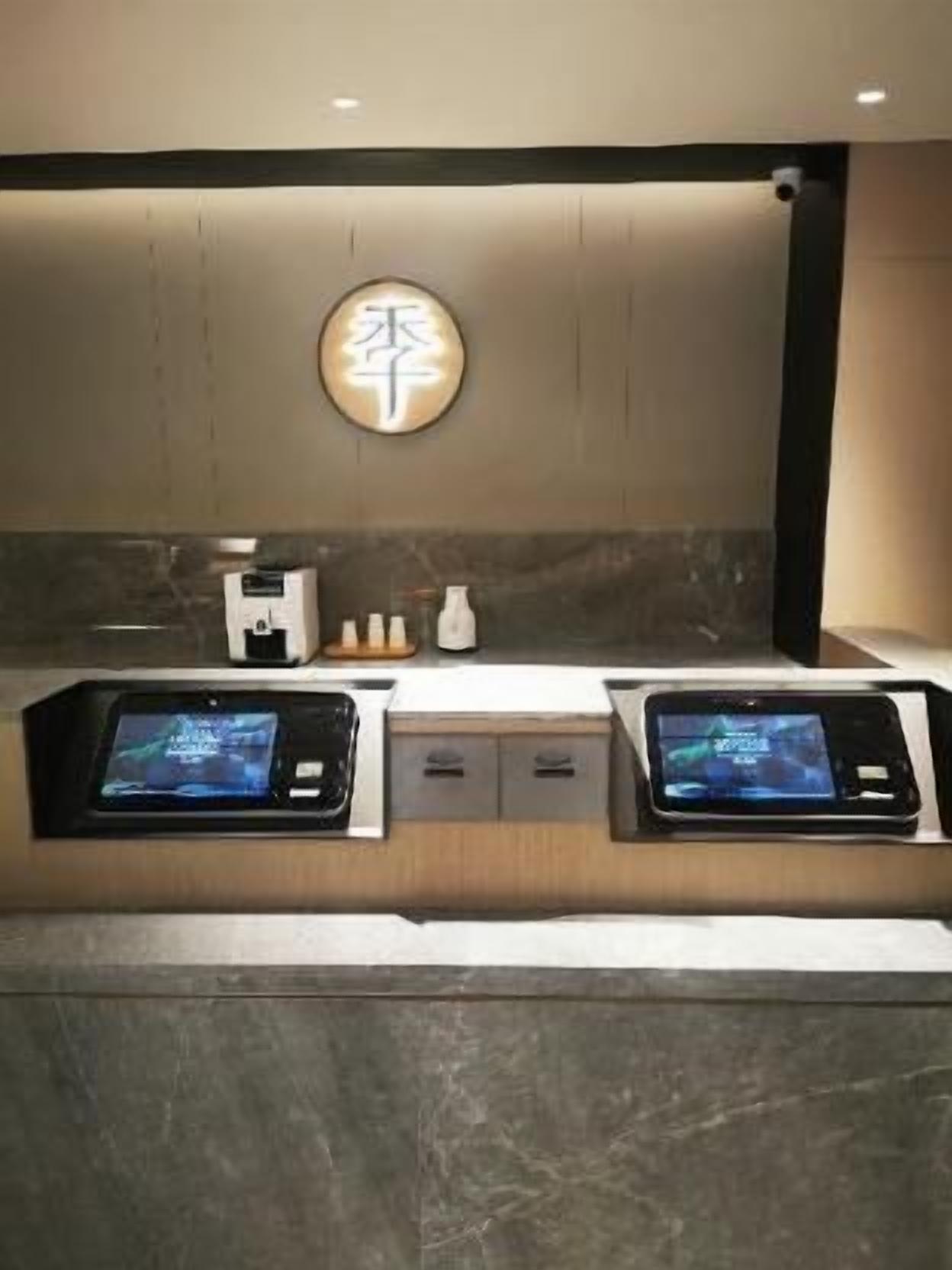 Une salle de bain moderne avec deux lavabos, un miroir et un luminaire fixé au mur.