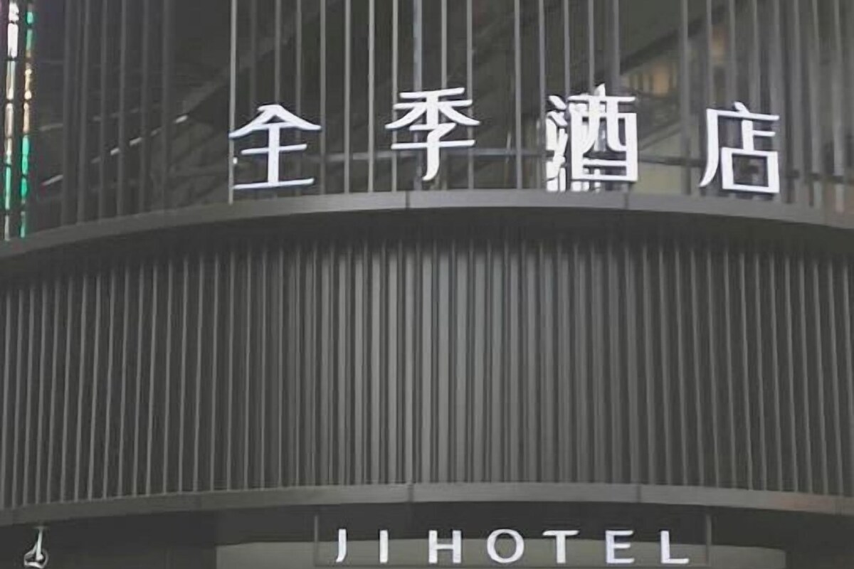 L’entrée d’un hôtel au design moderne, caractérisée par une large avancée et des portes en verre.