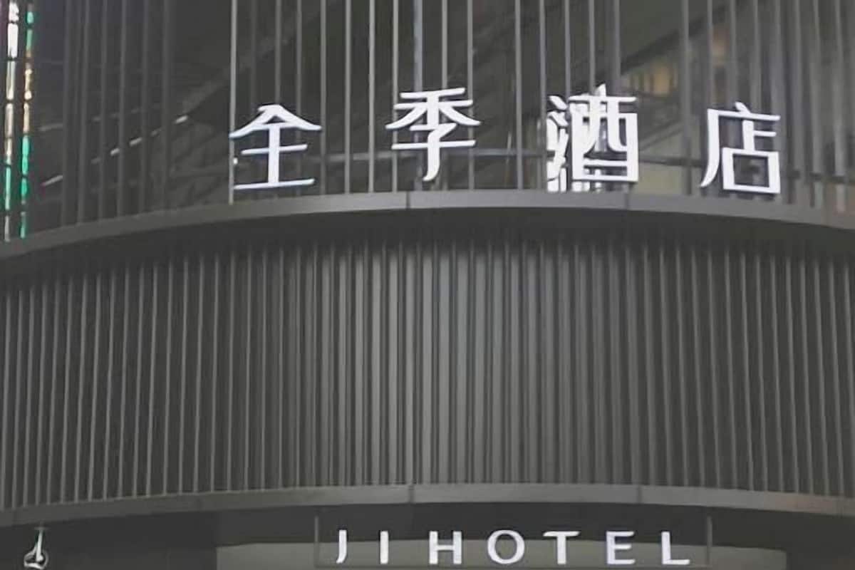 A hotel entrance with a modern design, featuring a large overhang and glass doors.