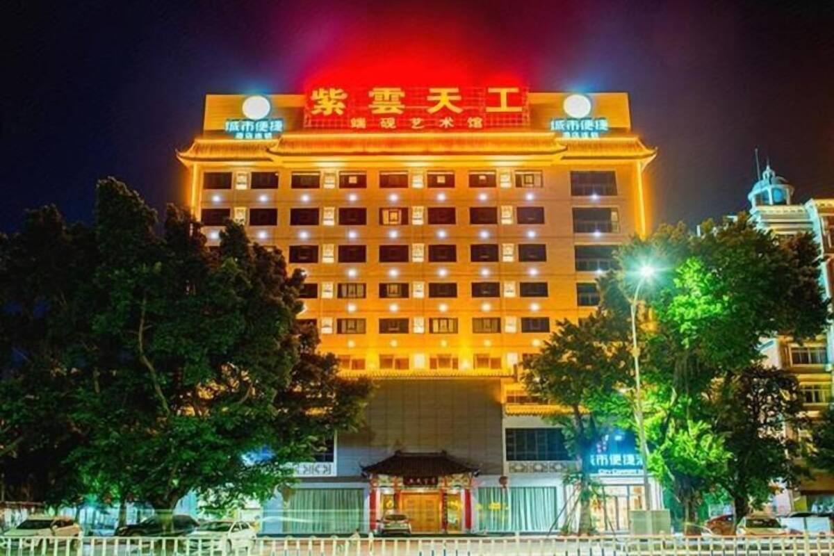 A multi-story hotel with a prominent red sign at the top, multiple windows, and a traditional architectural style.