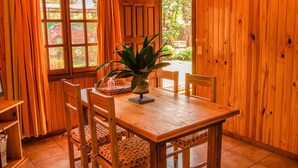 A wooden dining area with a table, chairs, and a potted plant. - El Descanso Iguazú by DOT Cabana (Puerto Iguazú)