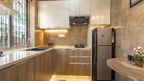 A modern kitchen with wooden cabinets, a stainless steel refrigerator, and a built-in oven.