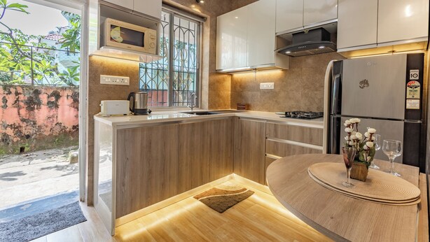 A modern kitchen with a built-in microwave, stainless steel appliances, and a wooden countertop.
