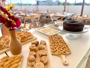A buffet table with various baked goods and a cake. - Porto Vila by AFT (Ipojuca)