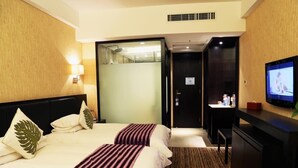 A hotel room with two beds, a desk, a television, and a bathroom. - Nanchang Ssaw Hotel (Nanchang)