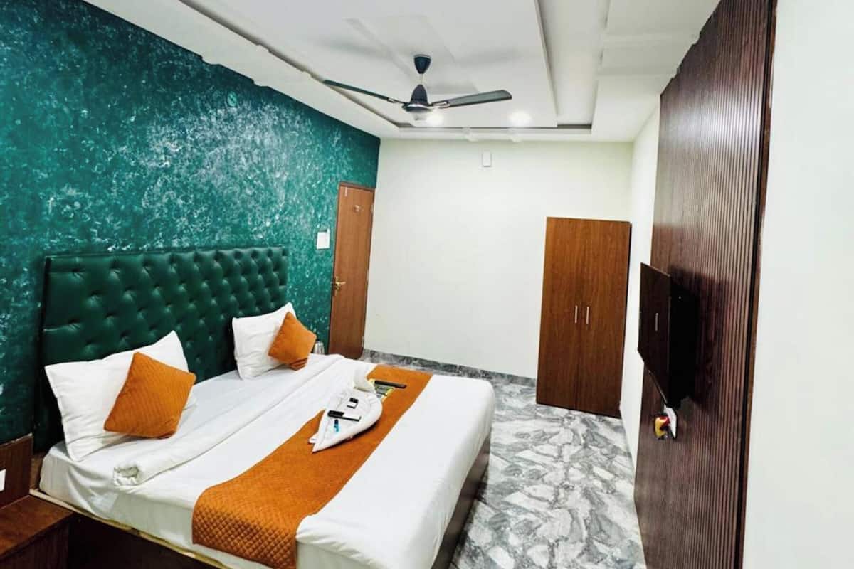 A hotel room with a bed, a ceiling fan, a wardrobe, and a marble floor.