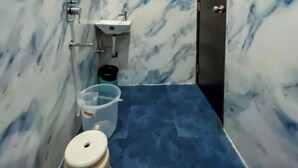 Ein Badezimmer mit Marmorwänden, einem Waschbecken, einer Toilette und einer Dusche.