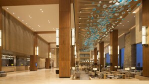 A spacious lobby with high ceilings, wooden paneling, and a reception desk. - Crowne Plaza Hangzhou Thousand Island Lake (Hangzhou)