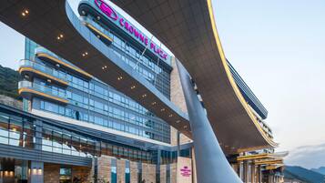 A modern building with a curved roof and a sign that reads 'CROWNE PLAZA.'