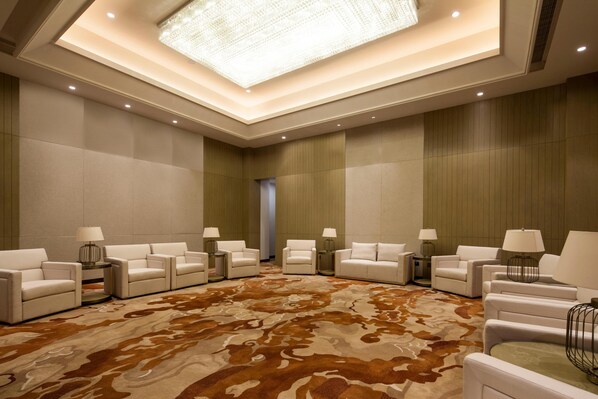 A spacious room with a patterned carpet, multiple white sofas, and lamps on side tables. - Crowne Plaza Hangzhou Thousand Island Lake (Hangzhou)
