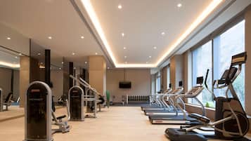 Un gimnasio con cintas de correr, elípticas y máquinas de pesas.