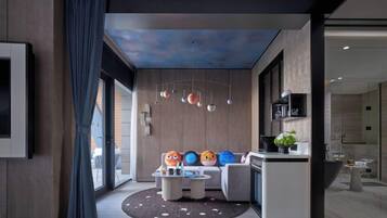 A modern interior with a seating area, a kitchen, and a ceiling with a celestial design.