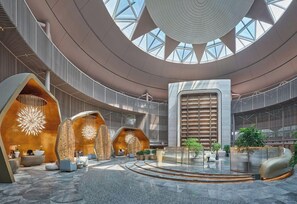 A spacious lobby with a central staircase, a large skylight, and modern seating areas. - Crowne Plaza Shanghai Harbour City (Shanghai)