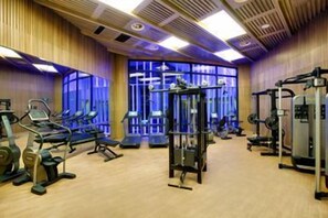 A gym with various exercise equipment, wooden floors, and large windows. - Crowne Plaza Shanghai Harbour City (Shanghai)