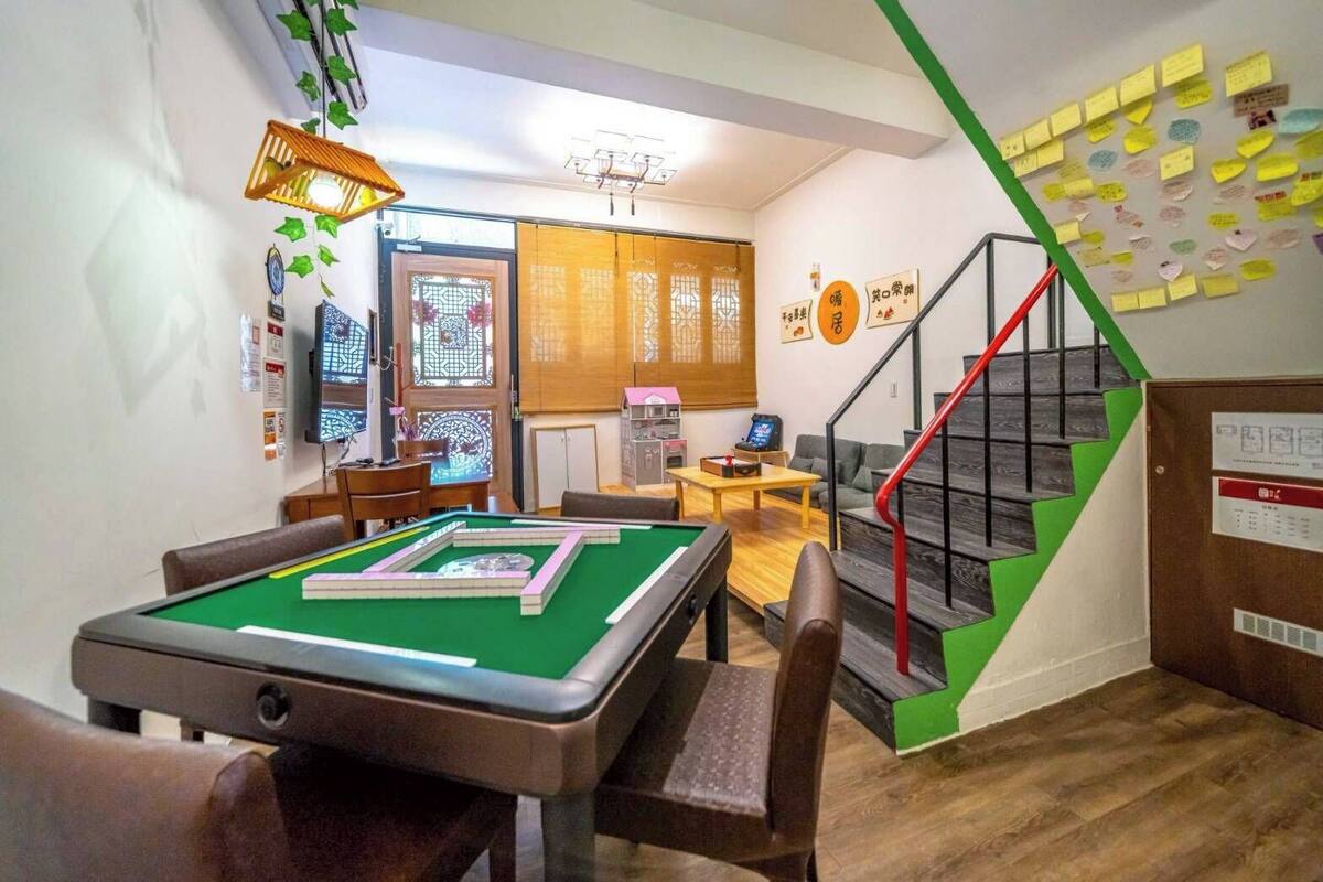 Une table de billard, un escalier et un mur couvert de notes.