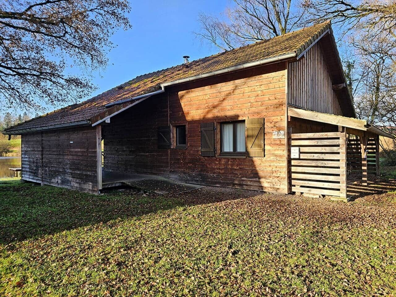 A rustic barn-style building with a sloped roof, a wooden door, and a window.
