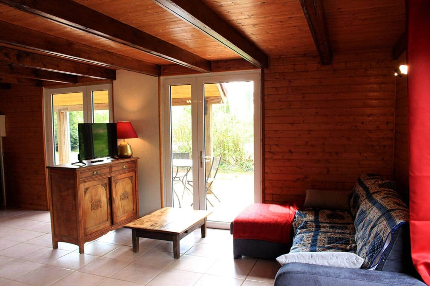 Un intérieur en bois comprenant un canapé, un meuble en bois, un téléviseur et un banc.