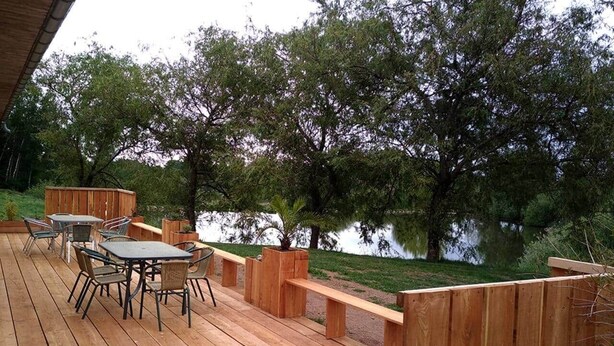 A wooden deck with outdoor furniture and a view of a lake. - La Ferme - House with terrace (Mélisey)