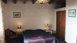 A bedroom with a bed, two bedside tables with lamps, a chair, a wardrobe, and a ceiling light fixture. - La Ferme - House with terrace (Mélisey)