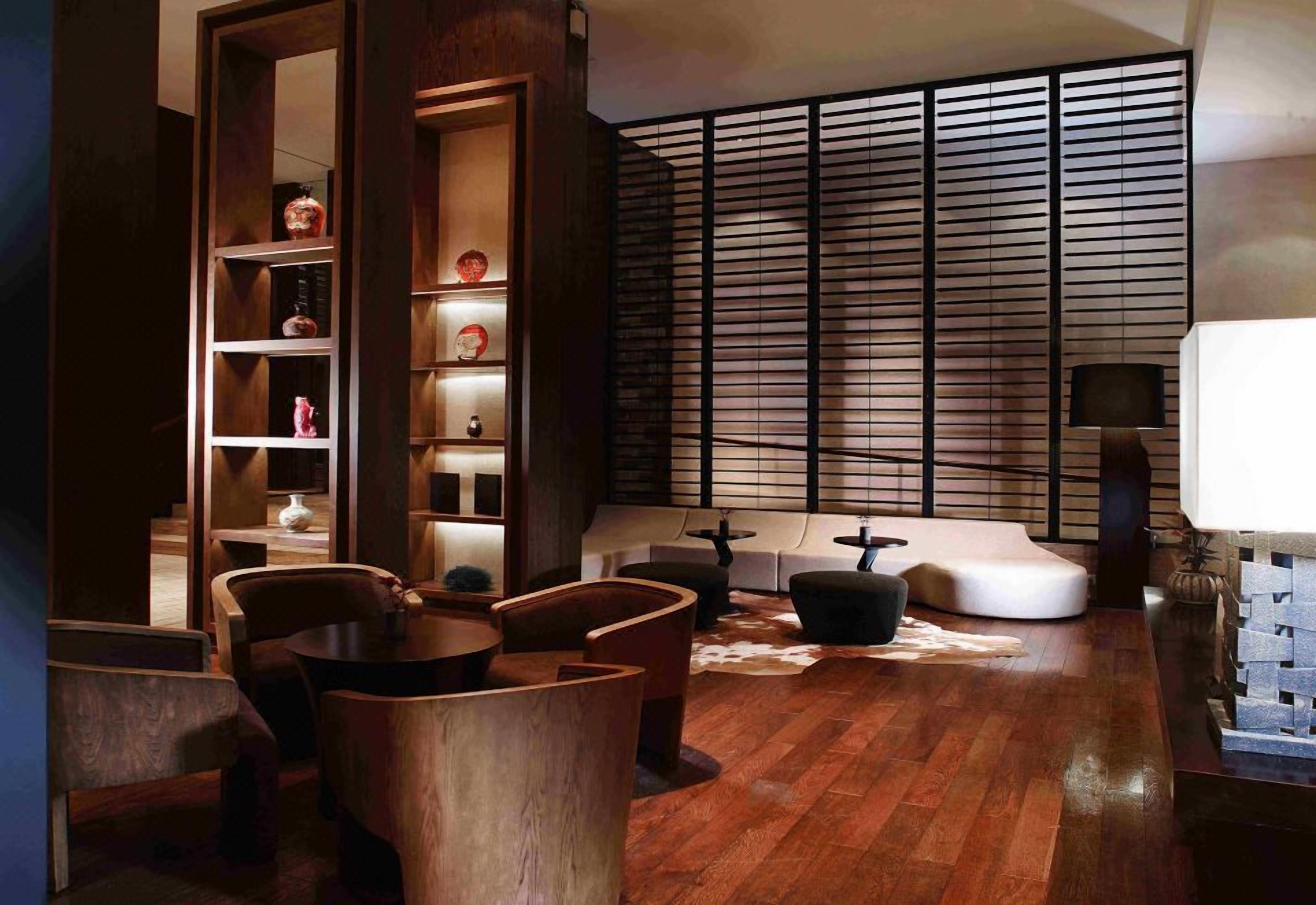 A modern living room with a wooden floor, a bookshelf, a sofa, and a TV.