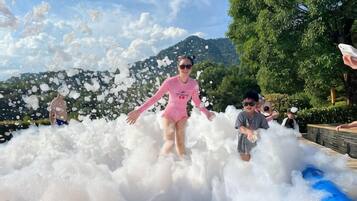 A person in a pink swimsuit playing in a large foam-filled area.
