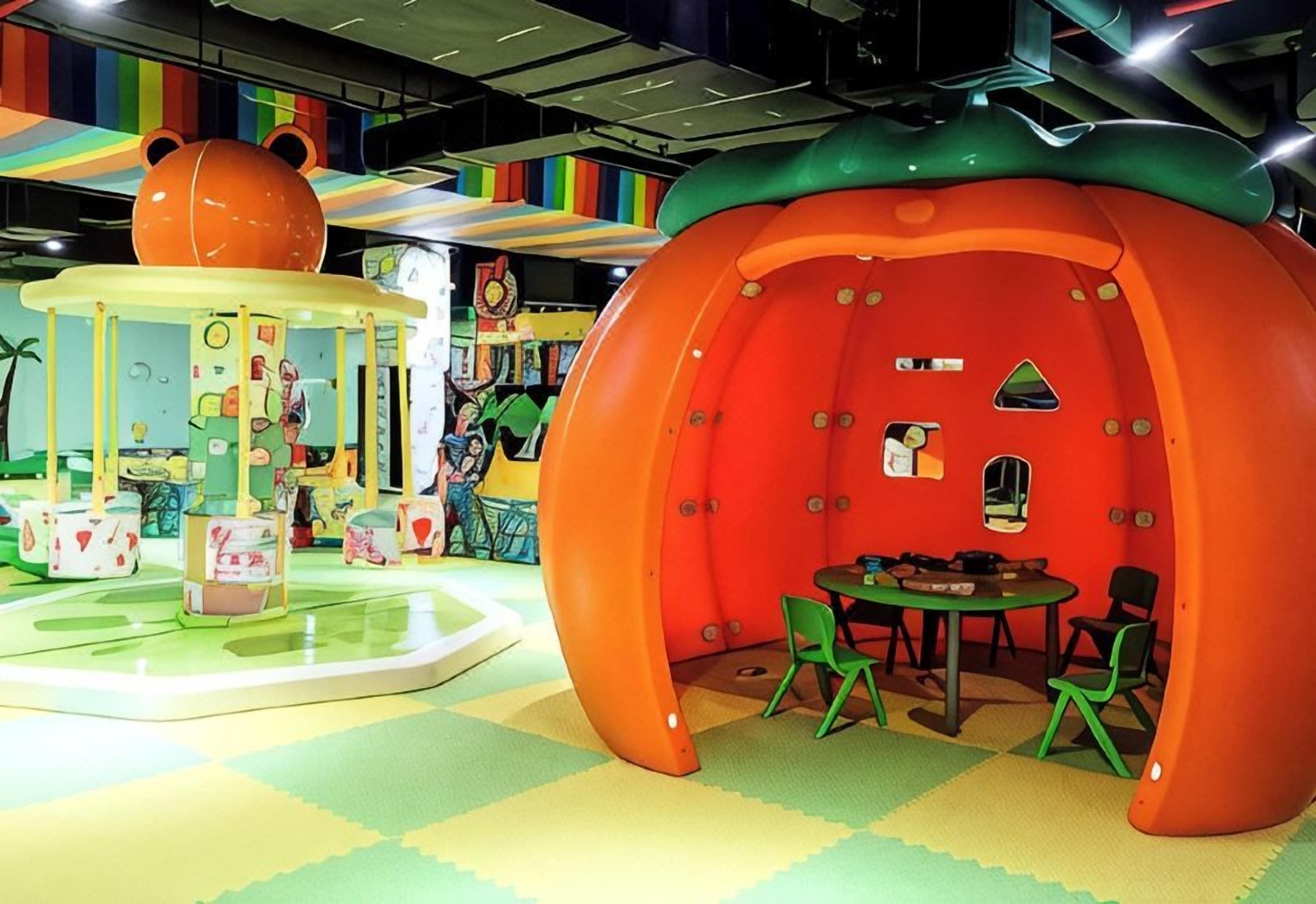A children's play area with colorful play structures and seating.
