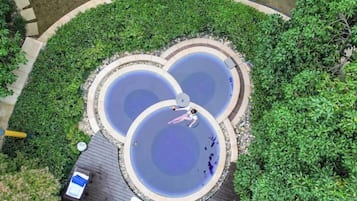 A circular water feature with a person relaxing in the center, surrounded by a landscaped garden.