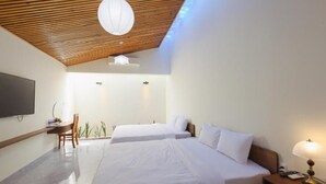 A modern hotel room with two beds, a flat-screen TV, a wooden ceiling, and a small desk with a chair. - SON HAI HOMESTAY (Hue)