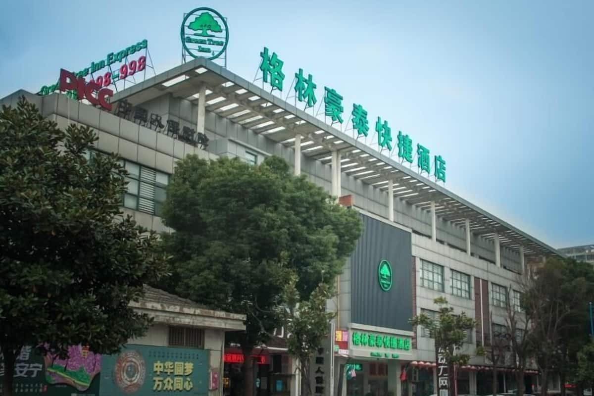 A hotel with a modern architectural design, featuring a prominent green logo and signage.